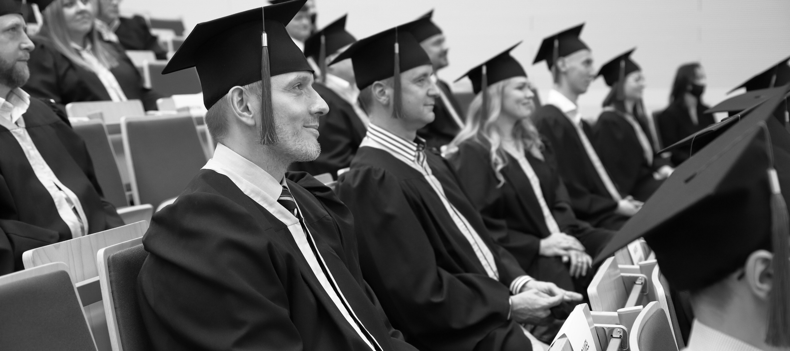 Zdjęcie absolwentów siedzących na auli